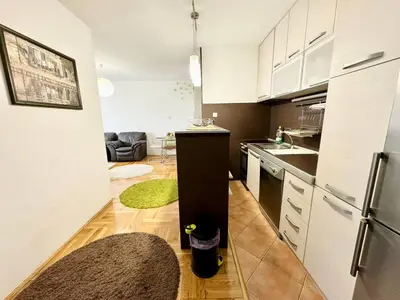 a kitchen with white cabinets and a black refrigerator at Şehir merkezi manzaralı modern in Podgorica