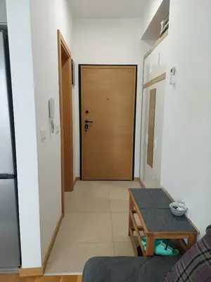 a hallway with a wooden door and a table at TiN Apartment in Ulcinj