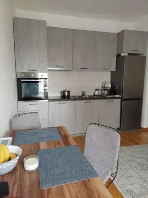 a kitchen with a wooden table and a dining room at TiN Apartment in Ulcinj