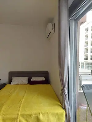 a bedroom with a yellow bed next to a window at TiN Apartment in Ulcinj