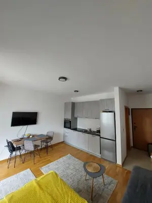 a living room with a table and a refrigerator at TiN Apartment in Ulcinj
