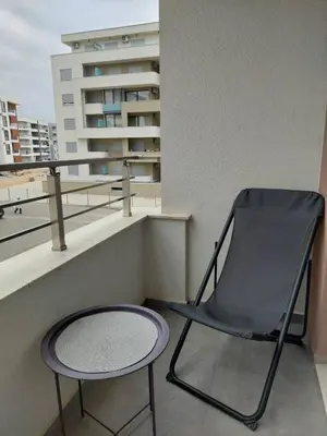 a chair and a table on a balcony at TiN Apartment in Ulcinj