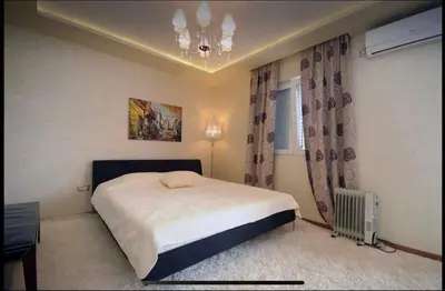 a bedroom with a large bed and a chandelier at Apartment Relax Petrovac in Petrovac na Moru