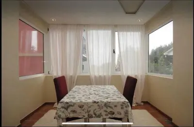 a dining room with a table and two windows at Apartment Relax Petrovac in Petrovac na Moru