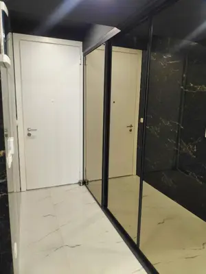an empty room with two doors and a tile floor at Apartmani Đurović in Becici
