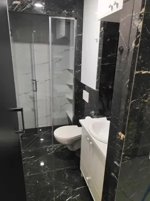 a bathroom with a toilet and a glass shower at Apartmani Đurović in Becici