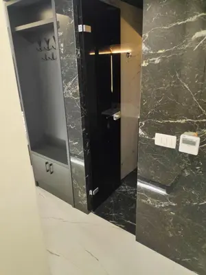 a mirror in a bathroom with a black marble wall at Apartmani Đurović in Becici