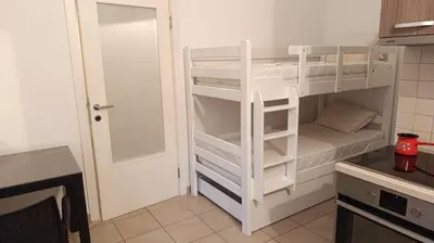 a white bunk bed in a kitchen next to a door at Cozy 2-Bedroom Apartment in Bigovo