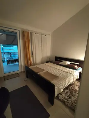 a bedroom with a large bed and a window at Cozy 2-Bedroom Apartment in Bigovo