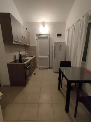 a kitchen with a refrigerator and a table in it at Cozy 2-Bedroom Apartment in Bigovo
