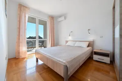 a bedroom with a bed and a balcony at Katarina17 in Becici