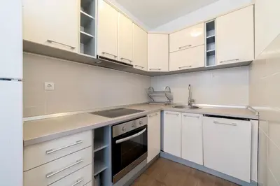 a kitchen with white cabinets and a sink at Katarina17 in Becici
