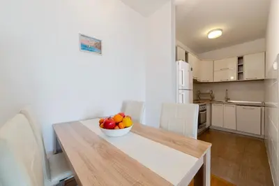 a kitchen with a table with a bowl of fruit on it at Katarina17 in Becici