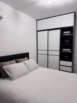 a bedroom with a white bed and a black cabinet at Ponte Nuovo De Luxe Apartment in Ulcinj