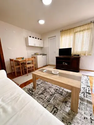 a living room with a coffee table and a kitchen at Zinzula 3 in Bar, Susanj