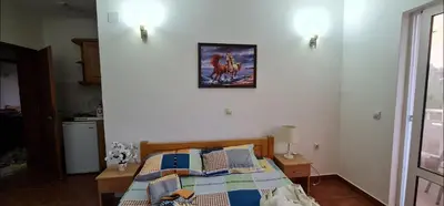 a bedroom with a bed with a picture on the wall at OliveGarten Apartments in Ulcinj