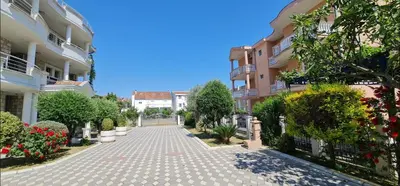 a cobblestone street in a courtyard between two buildings at OliveGarten Apartments in Ulcinj