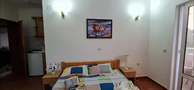 a bedroom with a bed with a picture on the wall at OliveGarten Apartments in Ulcinj