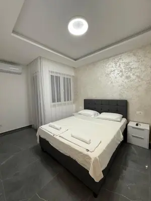 a bedroom with a large bed with white sheets at Skyline View Apartment in Ulcinj