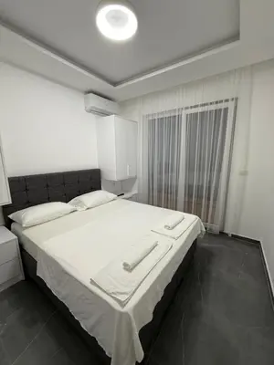 a bedroom with a large bed with white sheets at Skyline View Apartment in Ulcinj
