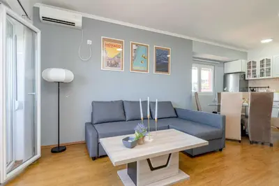 a living room with a blue couch and a table at Azzurro Apartment in Utjeha in Utjeha