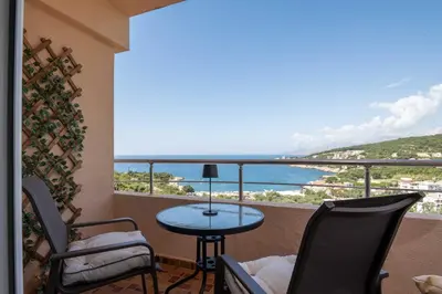 a balcony with a table and chairs and a view of the ocean at Azzurro Apartment in Utjeha in Utjeha