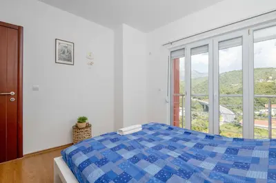 a bedroom with a bed and a large window at Azzurro Apartment in Utjeha in Utjeha