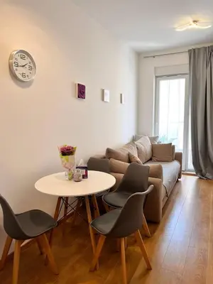 a living room with a couch and a table and chairs at Pretty apartment near the sea! in Budva