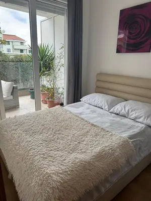 a bed in a bedroom with a large window at Pretty apartment near the sea! in Budva