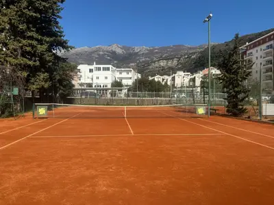 a tennis court with a net on top of it at Pretty apartment near the sea! in Budva