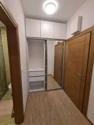 a room with a walk in closet with wooden cabinets at Pretty apartment near the sea! in Budva