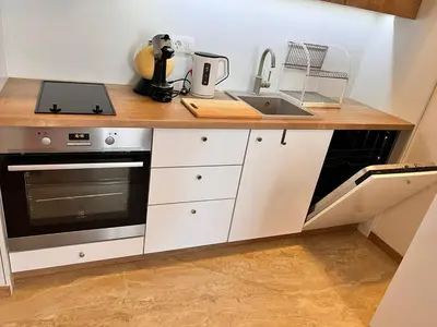 a kitchen with a counter with a sink and a stove at Pretty apartment near the sea! in Budva