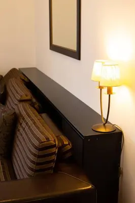a lamp sitting on a table next to a couch at SOHO CITY Grunevs apartments 2 in Bar