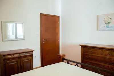 a bedroom with a bed and a wooden cabinet at SOHO CITY Grunevs apartments 2 in Bar
