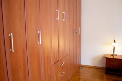 a large closet with wooden cabinets in a room at SOHO CITY Grunevs apartments 2 in Bar