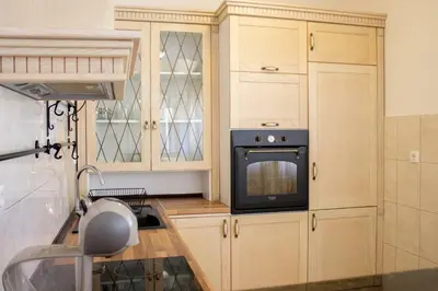 a kitchen with wooden cabinets and a microwave at SOHO CITY Grunevs apartments 2 in Bar