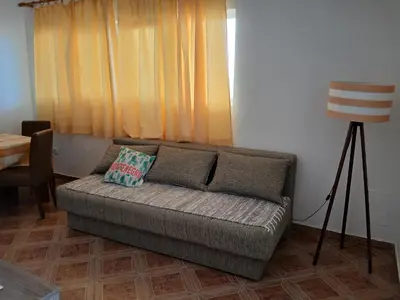 a living room with a couch in front of a window at Vila Marina in Buljarica