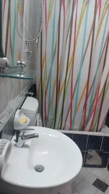 a bathroom with a white sink and a colorful wall at Vila Marina in Buljarica