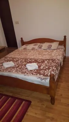 a bed in a bedroom with a wooden bed frame at Vila Marina in Buljarica