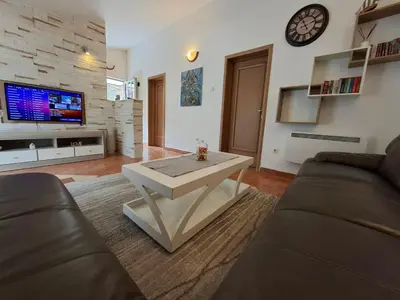 a living room with a couch and a table at Nina Apartment in Škaljari