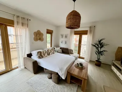 a bedroom with a bed and a couch at Salt & Stone Apartment in Sveti Stefan