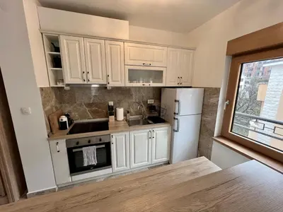 a kitchen with white cabinets and a white refrigerator at Salt & Stone Apartment in Sveti Stefan