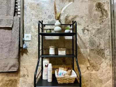 a black shelf with toiletries on it in a bathroom at Salt & Stone Apartment in Sveti Stefan