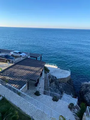 a view of the ocean with a bench and a parking lot at Biser mora in Dobra Voda