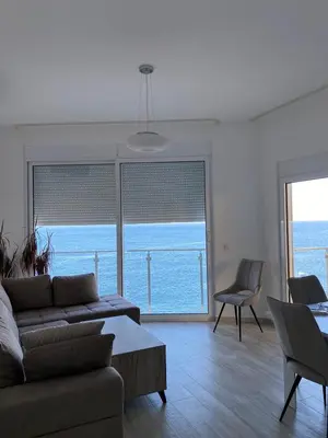 a living room with a couch and a view of the ocean at Biser mora in Dobra Voda