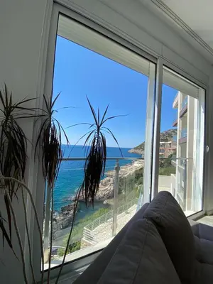 a room with a large window with a view of the ocean at Biser mora in Dobra Voda
