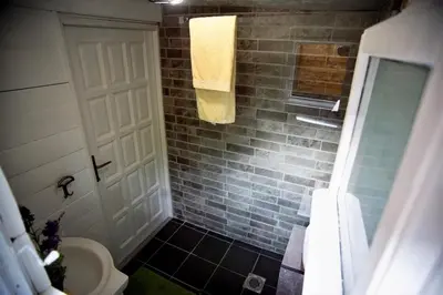a bathroom with a shower with a toilet and a towel at Suncica Ada Bojana in Ada
