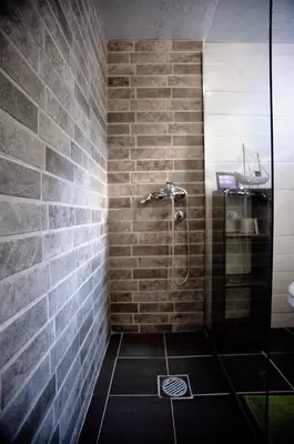 a bathroom with a shower with a brick wall at Suncica Ada Bojana in Ada