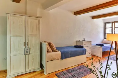 a bedroom with a bed and a dresser at Olea Apartments in Stari Bar