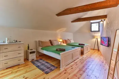 a bedroom with two beds and a wooden floor at Olea Apartments in Stari Bar